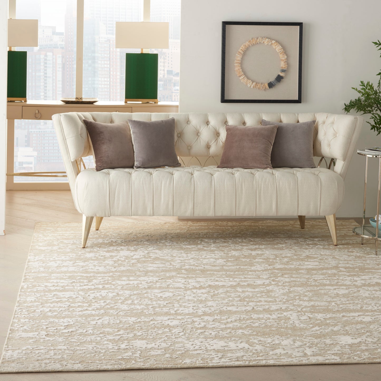 Beige textured rug in a modern living room, with a cream tufted sofa and taupe cushions, and circular rope wall art.
