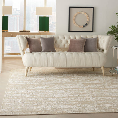 Beige textured rug in a modern living room, with a cream tufted sofa and taupe cushions, and circular rope wall art.