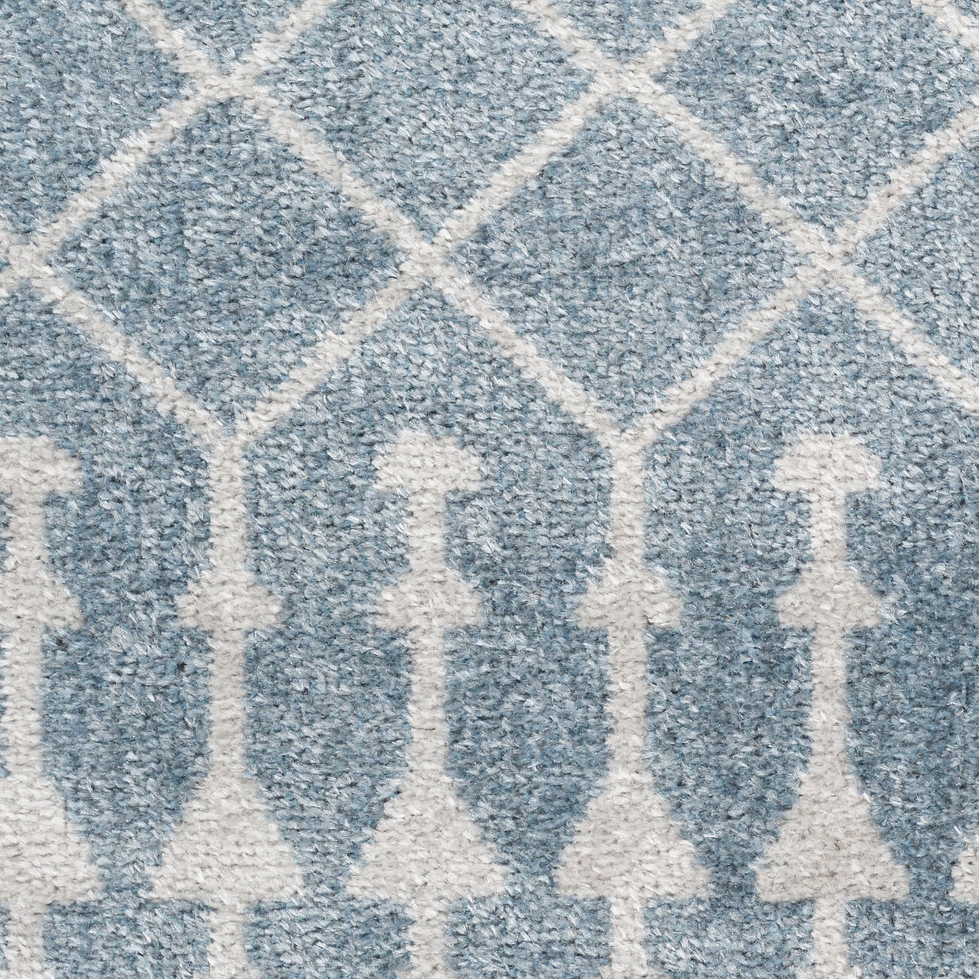 Blue-gray rug with white trellis diamond lattice and vertical motif, textured plush pile.