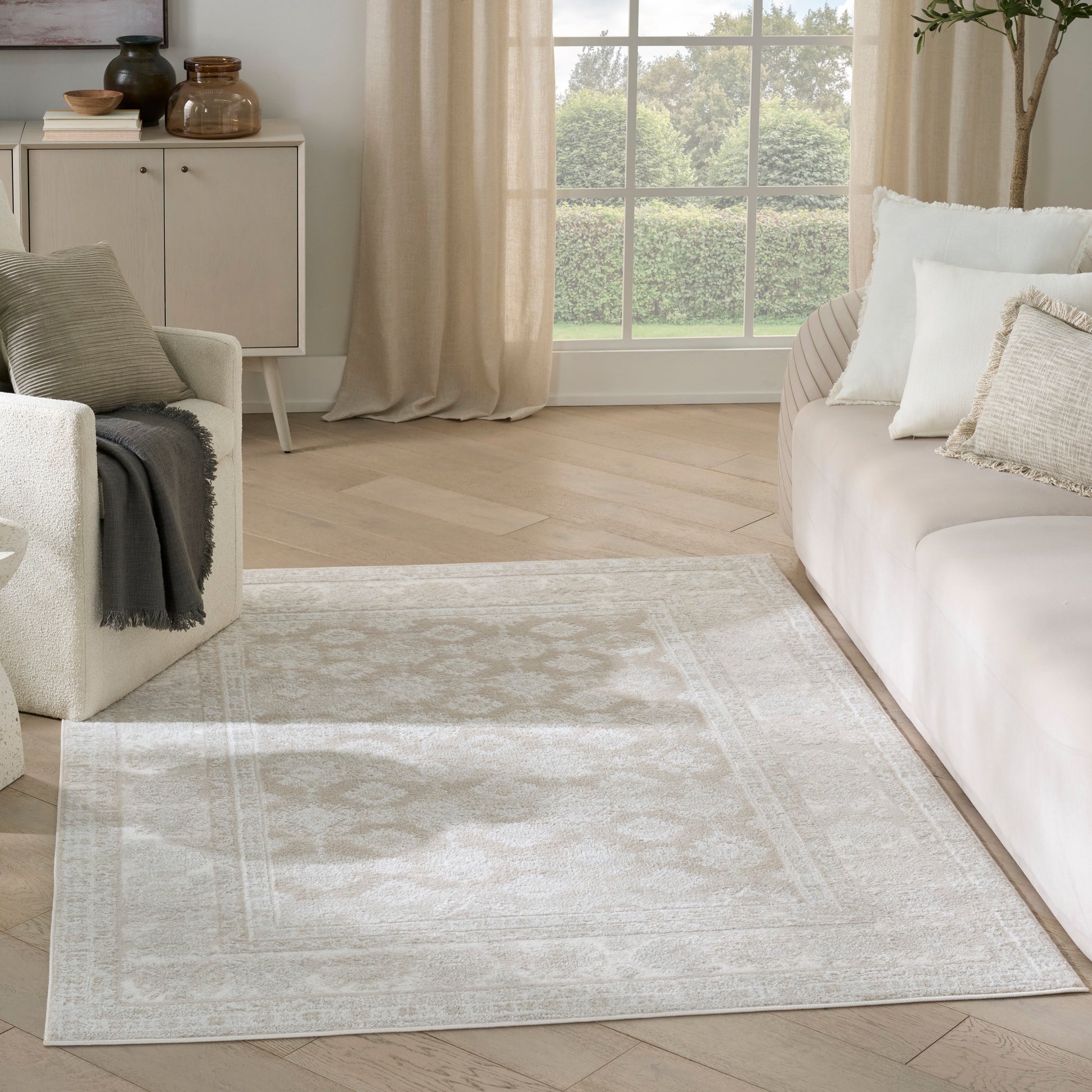 Cream patterned vintage 4' x 6' area rug on light wood floor, paired with a cream sofa and airy neutral living room decor.