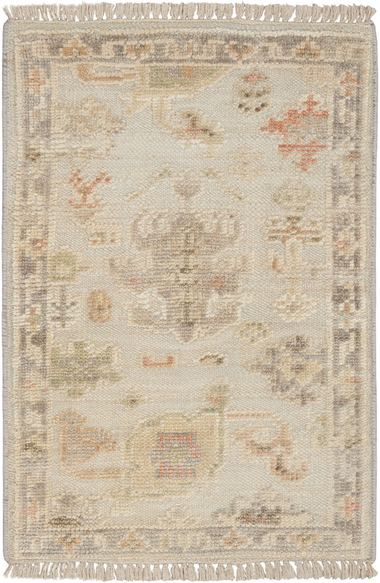 Rectangular cream-toned oriental rug with faded pastel medallion, floral motifs, and fringed ends; vintage-inspired decor.