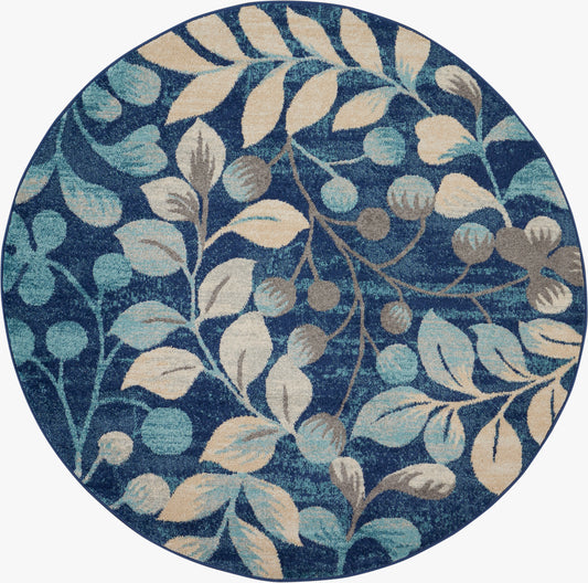 Round blue rug with cream and teal botanical leaves and berries; decorative floor accent.