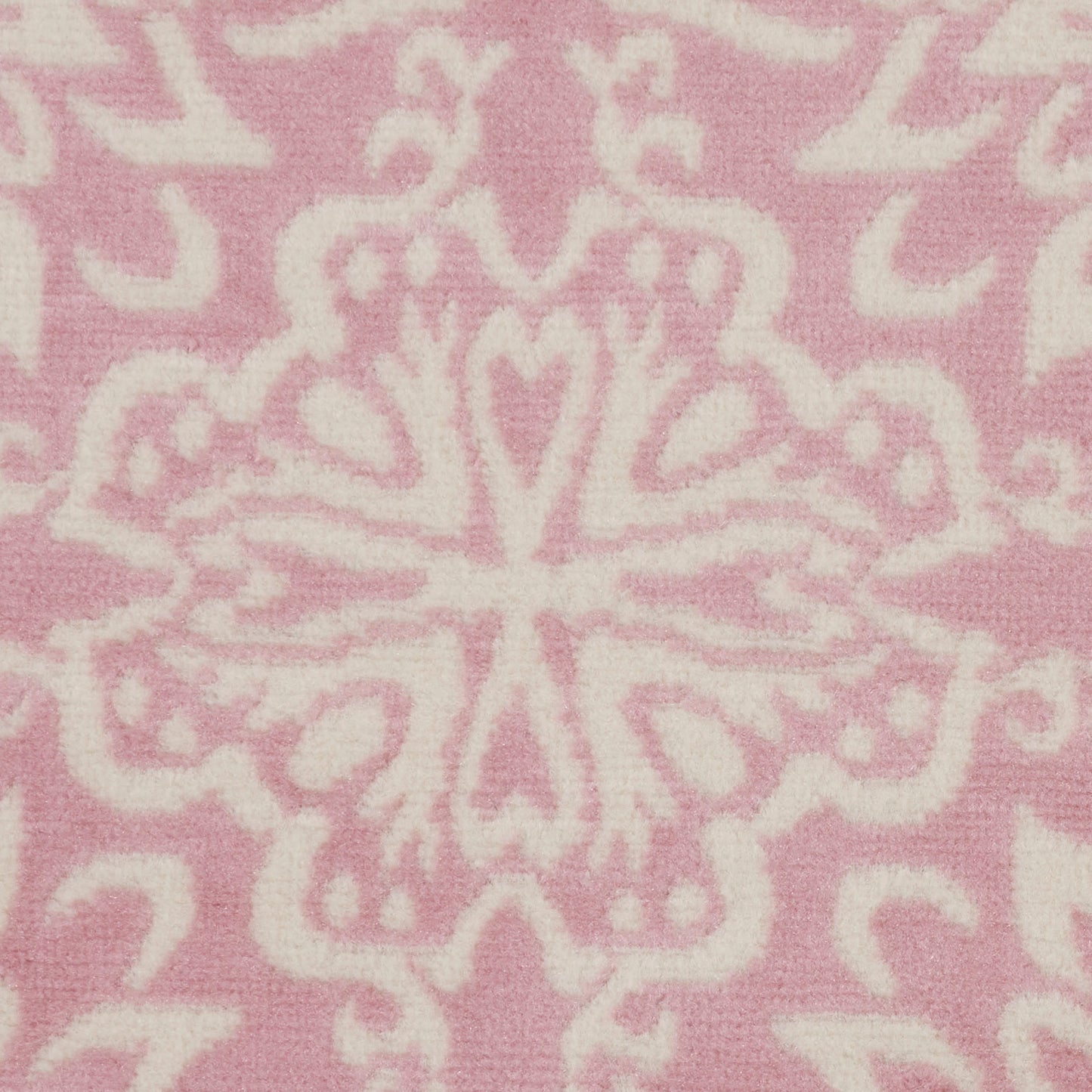 Pink textile with white damask-like floral motif, soft fabric texture; decorative home décor or throw blanket.