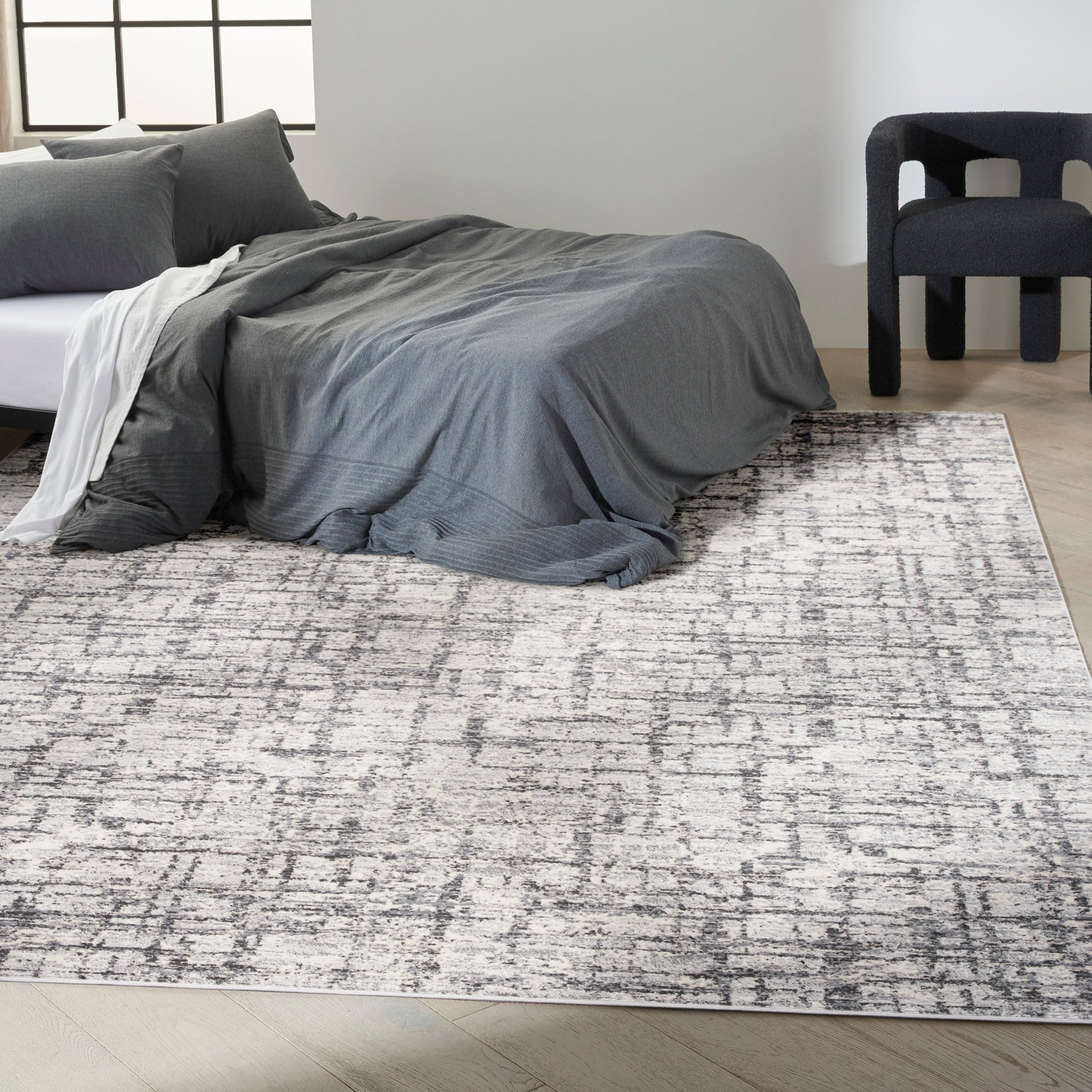 Grey abstract-pattern rug on a floor in a minimalist room.