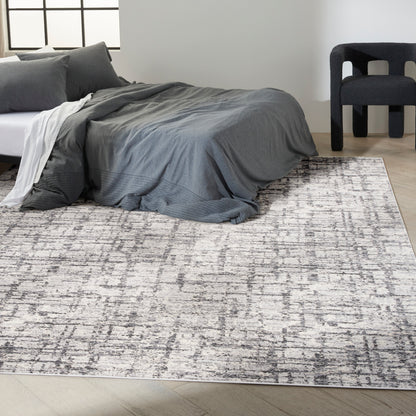 Grey abstract-pattern rug on a floor in a minimalist room.