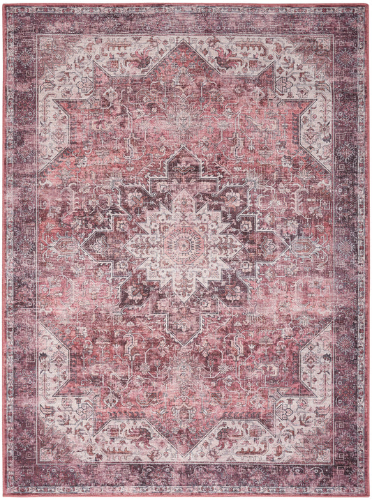 Distressed pink Persian-style area rug with ivory central medallion, ornate border and vintage floral motifs.