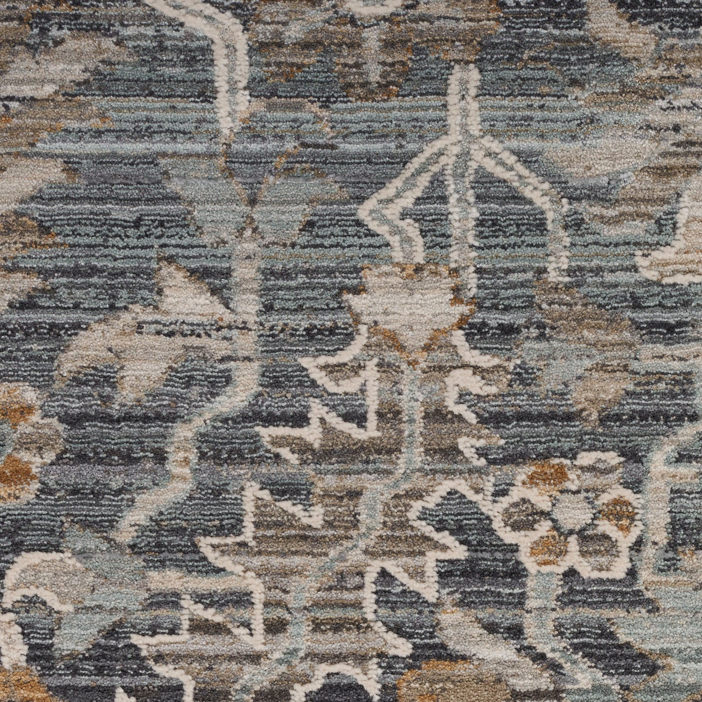 Distressed blue-gray oriental rug with ivory floral vine pattern and tan accents, woven living-room decor.