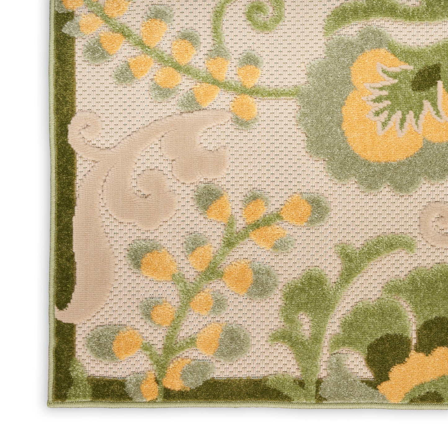 Close-up of ornate floral rug corner: olive border, beige background, yellow-orange blossoms, green vines, plush pile.