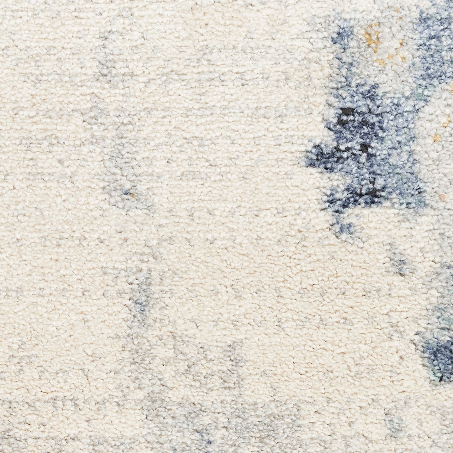 Cream shag rug with blue abstract patches; plush texture for cozy contemporary floor decor.