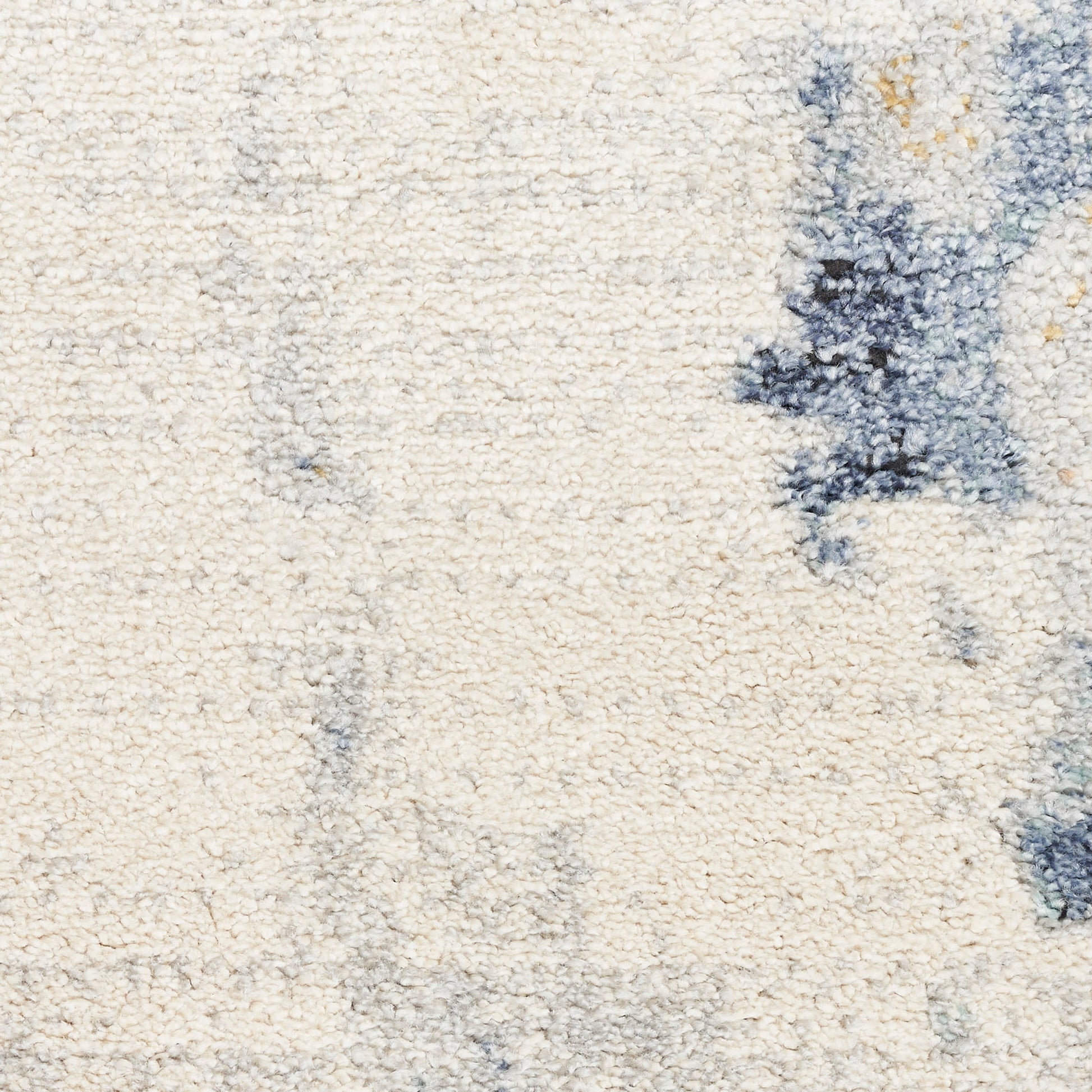 Cream shag rug with blue abstract patches; plush texture for cozy contemporary floor decor.