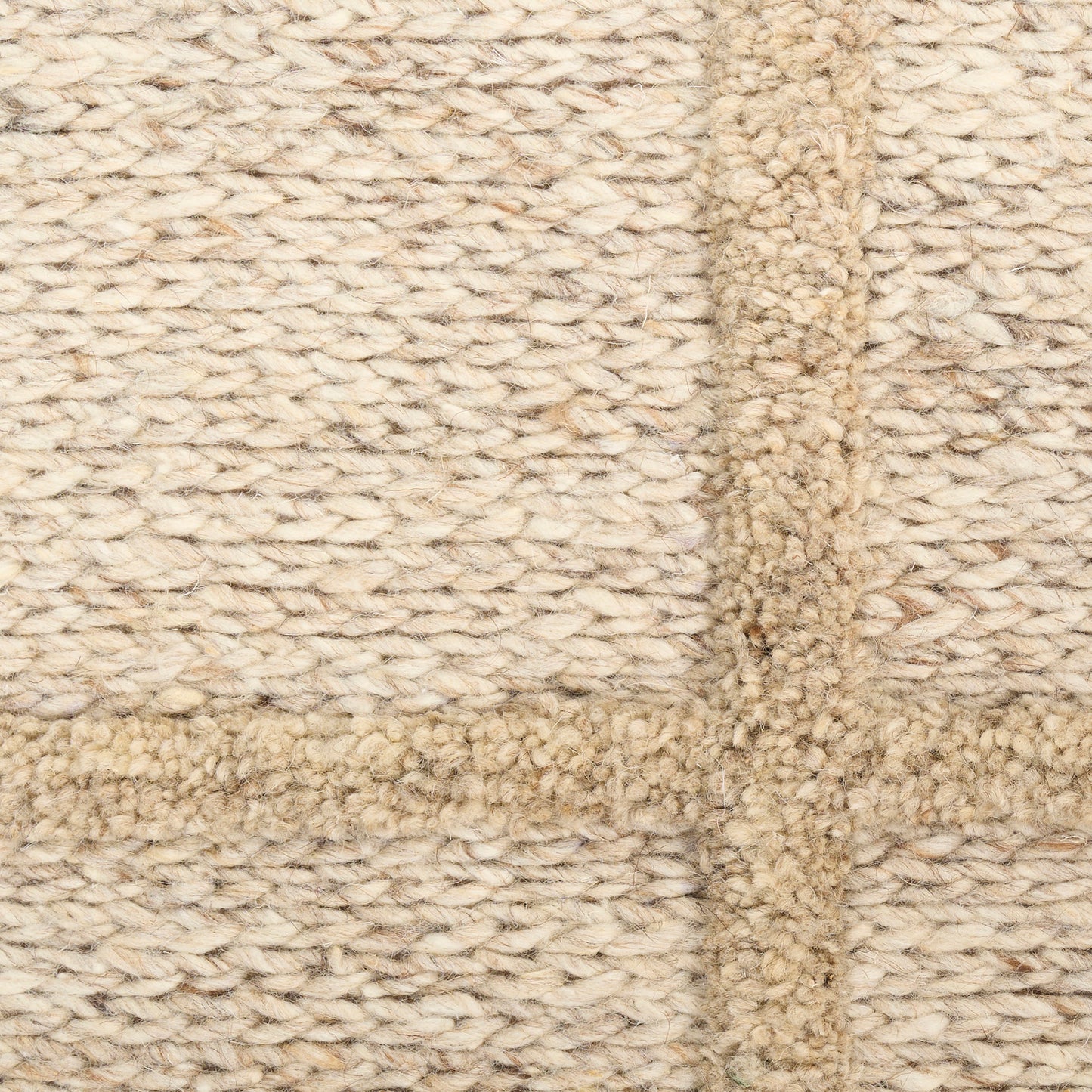 Beige knitted rug with a darker tan border, lighter cream field, thick looped texture and cross seam.