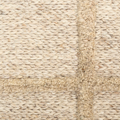 Beige knitted rug with a darker tan border, lighter cream field, thick looped texture and cross seam.