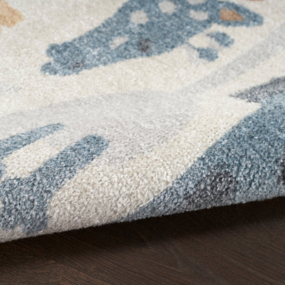 Soft textured kid's area rug with blue geometric motifs on a cream background; thick pile and folded edge.