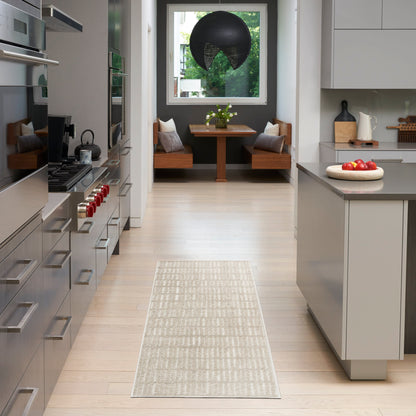 Sleek modern kitchen with stainless appliances, pale wood floors, gray island, beige runner rug, and a back dining nook.