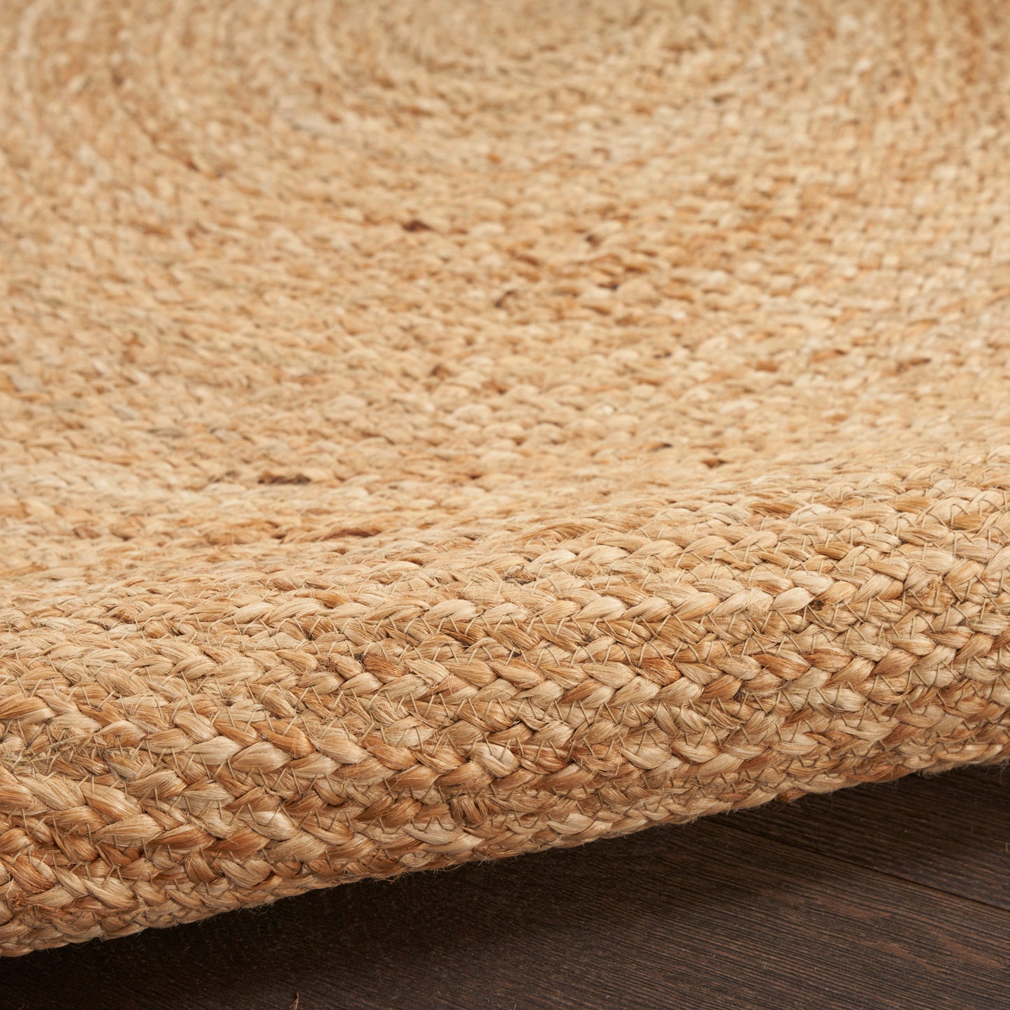 Round natural jute rug with chunky woven texture in warm beige; coastal rustic style.