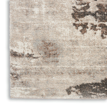 Neutral beige rug with cream & taupe tones; soft textured pile & abstract brown pattern.