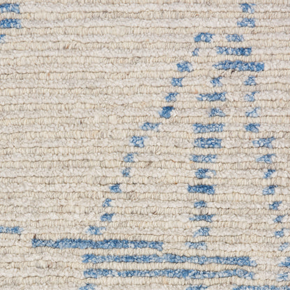 Cream textured woven rug with pale blue geometric lines and shapes.
