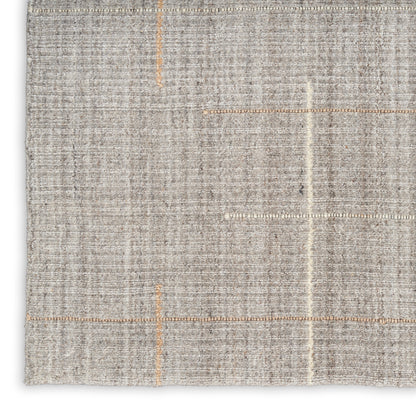 Light gray flatwoven rug with orange stitch lines and subtle textured weave.