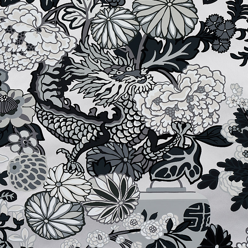 Monochrome dragon amid large grayscale flowers and leaves on fabric pattern.