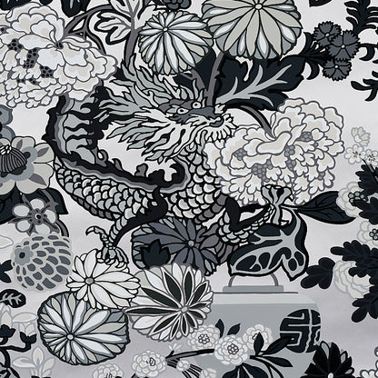 Monochrome dragon amid large grayscale flowers and leaves on fabric pattern.