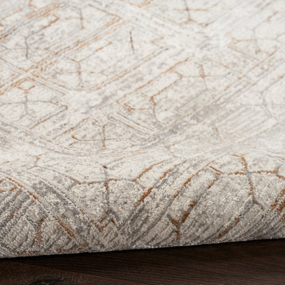 Cream textured rug with soft tufted pile and copper-toned geometric pattern on dark wood floor