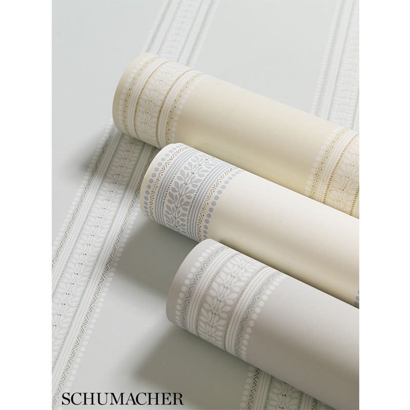 Three wallpaper rolls in limestone, cream and ivory with a Lorraine stripe pattern.