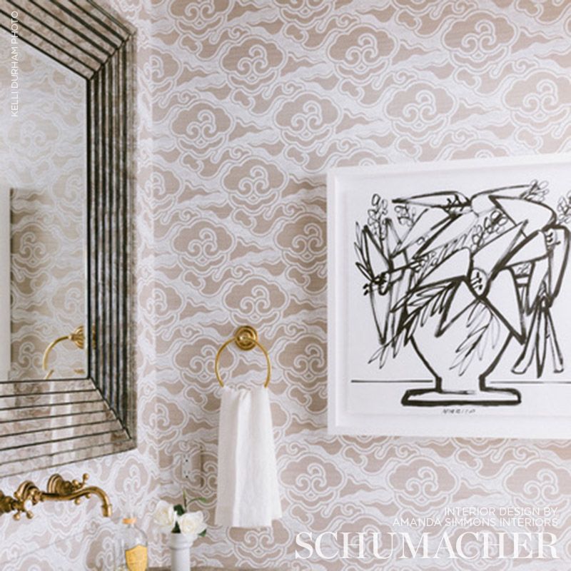 Powder-room decor: beige damask wallpaper, gold towel ring with white towel, black line-art in white frame, brass faucet near a striped mirror.