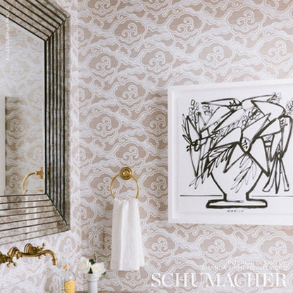 Powder-room decor: beige damask wallpaper, gold towel ring with white towel, black line-art in white frame, brass faucet near a striped mirror.