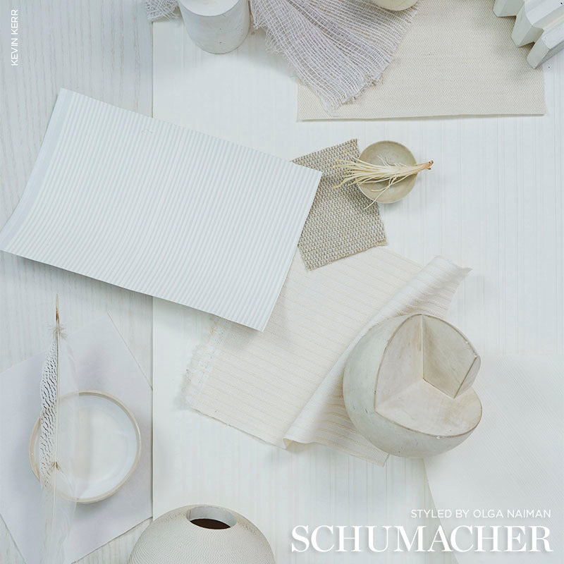 Ivory textured chevron wallcovering swatch flat lay with fabric swatches, textured papers, a ceramic heart bowl and dried plant accents.