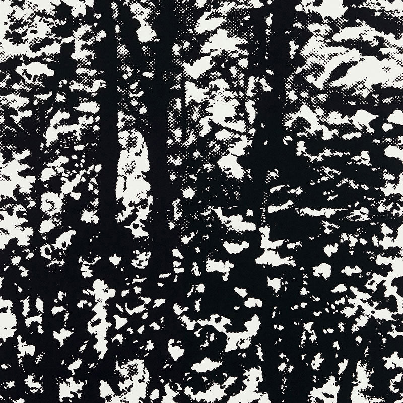 Monochrome black-and-white forest silhouette print with bold tree trunks and speckled foliage; graphic textile pattern.