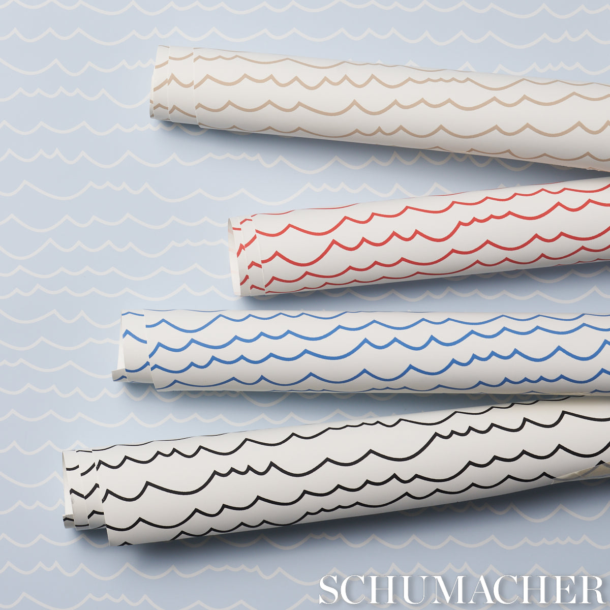 Schumacher wallpaper rolls with blue wavy scallop patterns on white, stacked diagonally.
