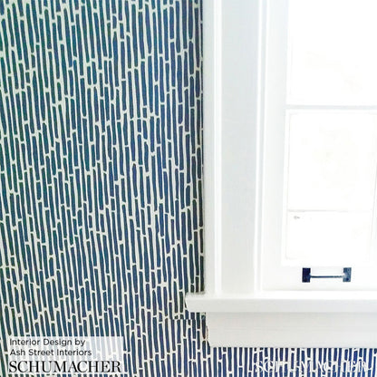 Taupe bamboo wallpaper with a drawn-from-nature motif beside a white window frame.