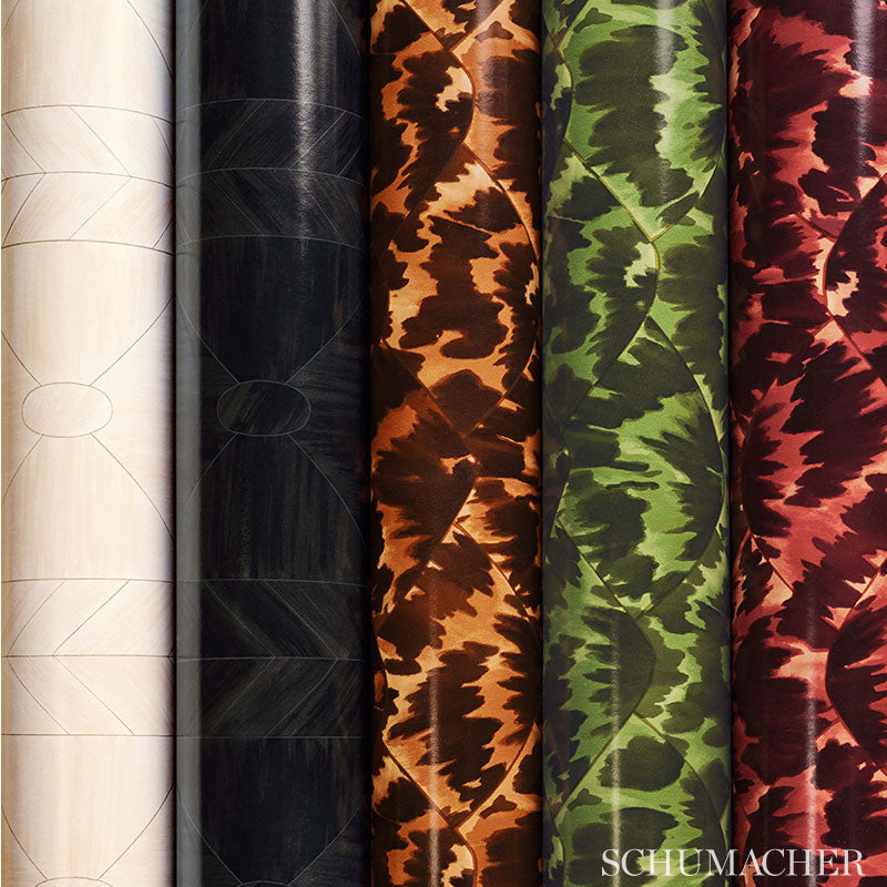 Vertical rolls of camouflage-pattern fabric in white, black, orange, green, and red hues.