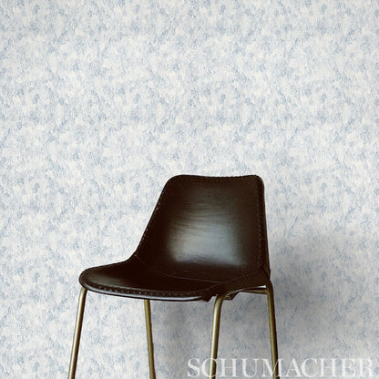Indigo feather-pattern wallcovering on a light background.