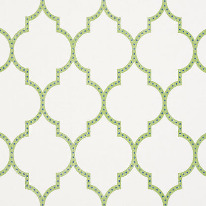Lime-green quatrefoil lattice wallpaper on cream background with blue dot accents; repeating geometric pattern.
