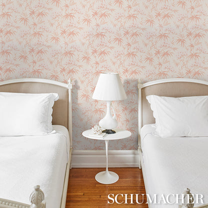 Twin bedroom with pink palm-pattern wallpaper, white bed frames, white bedding, and a white bedside table with a lamp.