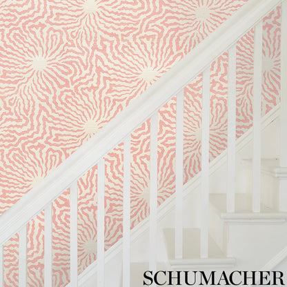 Pink and cream zebra-pattern wallpaper on staircase wall with white banister.