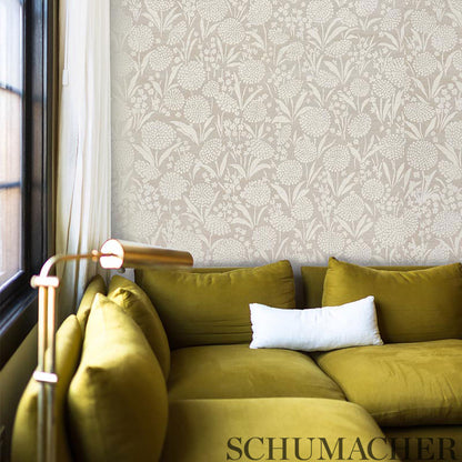 Mustard olive sofa with white lumbar pillow, brass floor lamp, and beige floral wallpaper by window.