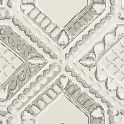 Cream-gray stone-look decorative tile pattern with a cross motif, scrollwork and scalloped borders.