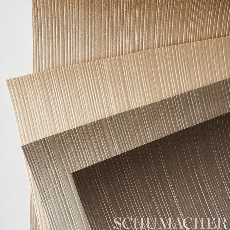 Stack of beige to brown textured wallcoverings with embossed vertical ridges.