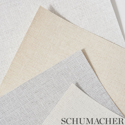 Schumacher wallcoverings swatches in beige, taupe, and gray with a linen-like woven texture, overlapping.