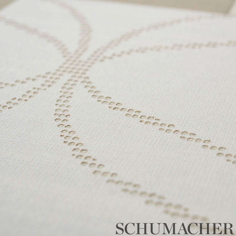 Cream cushion cover with beige dotted curved embroidery forming intersecting arcs.