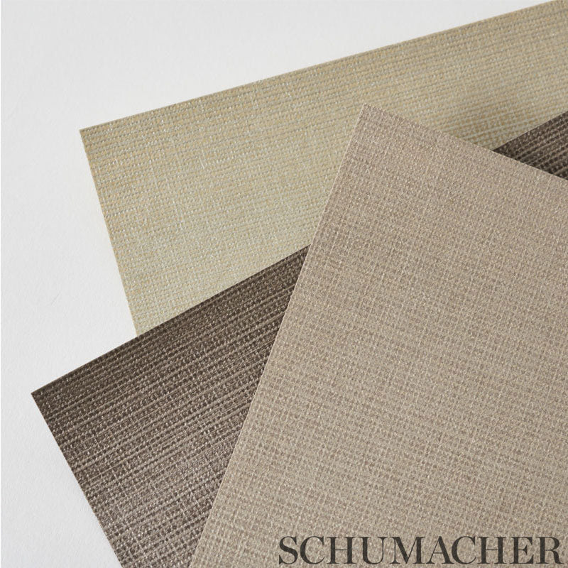 Overlapping linen-textured fabric swatches in beige, taupe and brown; woven look with Schumacher branding.