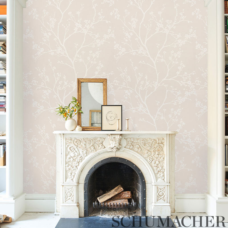 Blush vinyl wallpaper with a pale pink botanical pattern on the walls; decor includes frames, a vase with plant, and a candle.
