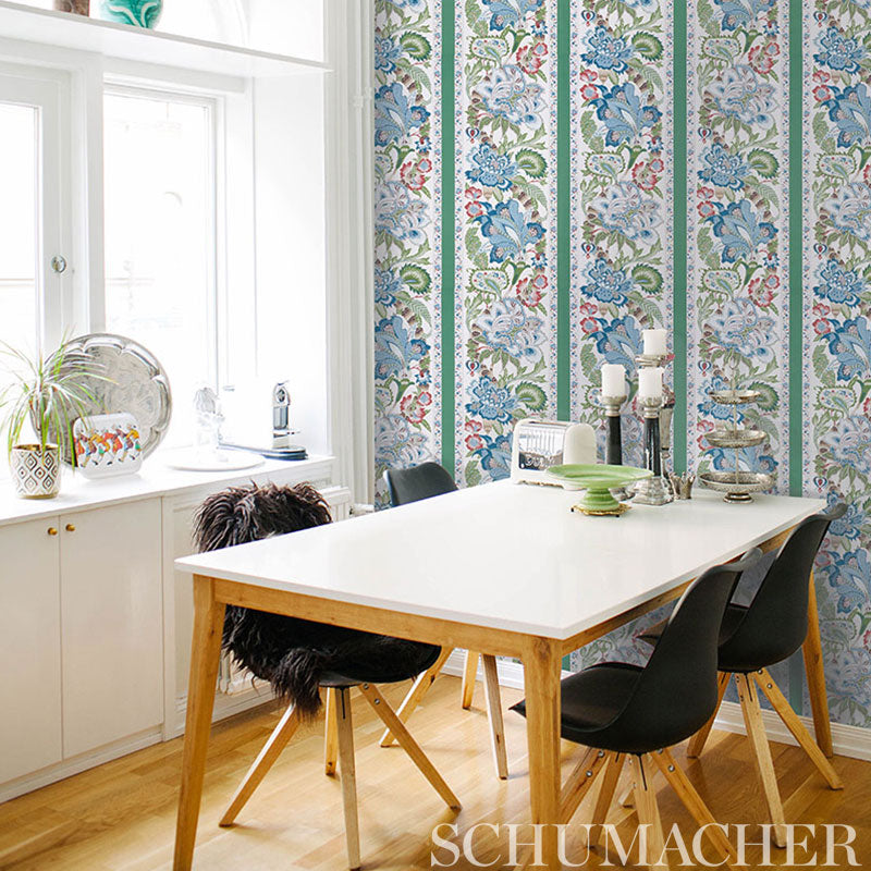 Emerald green stripe wallpaper on the wall behind a dining area with a white rectangular table and four black chairs
