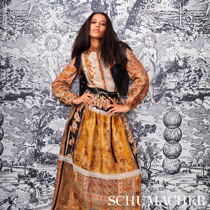 Boho floral maxi dress in ochre, brown and cream with lace trim, paired with a black vest and belt, against toile wallpaper.