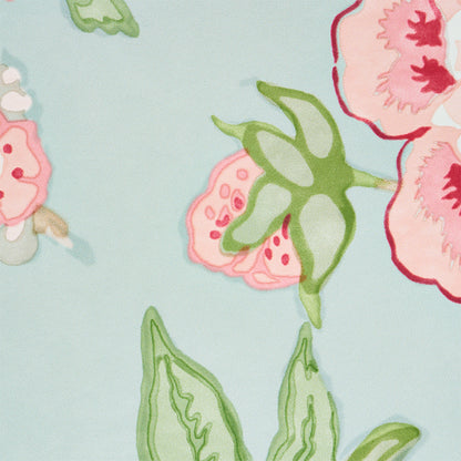 Watercolor-style floral fabric in pale blue with pink & red blossoms and green leaves