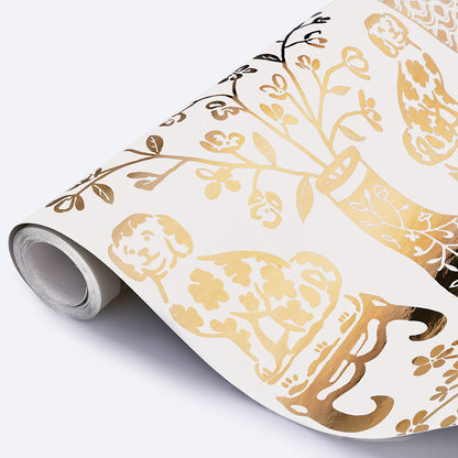 Gold foil botanical wallpaper roll with vines, leaves and blossoms on white background; metallic finish.