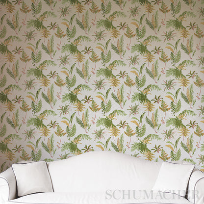 Botanical tropical wallpaper in greens, yellows and browns behind a white sofa with cushions.