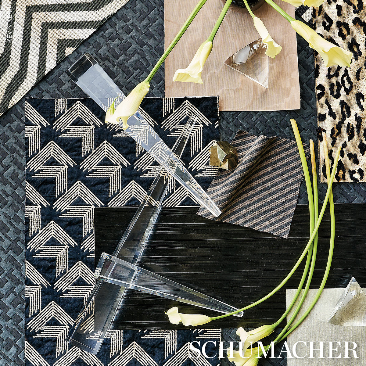 Assorted fabric swatches with geometric patterns in navy, cream, beige; clear acrylic rulers and yellow calla lilies.